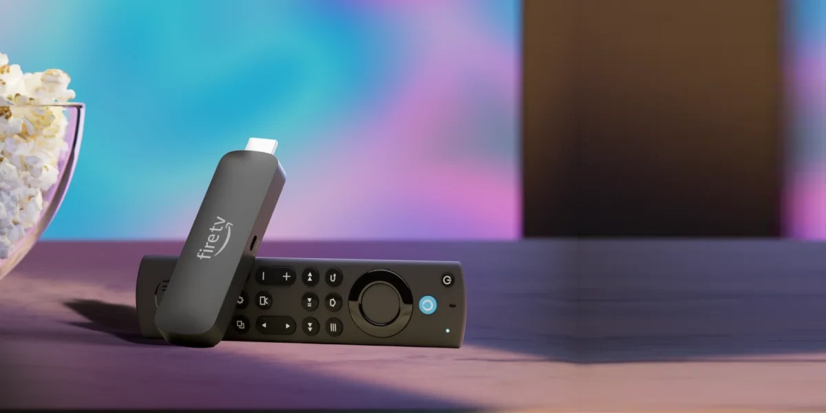 Amazon Fire TV Stick mit Alexa-Sprachfernbedienung vor einem farbig leuchtenden Fernseher